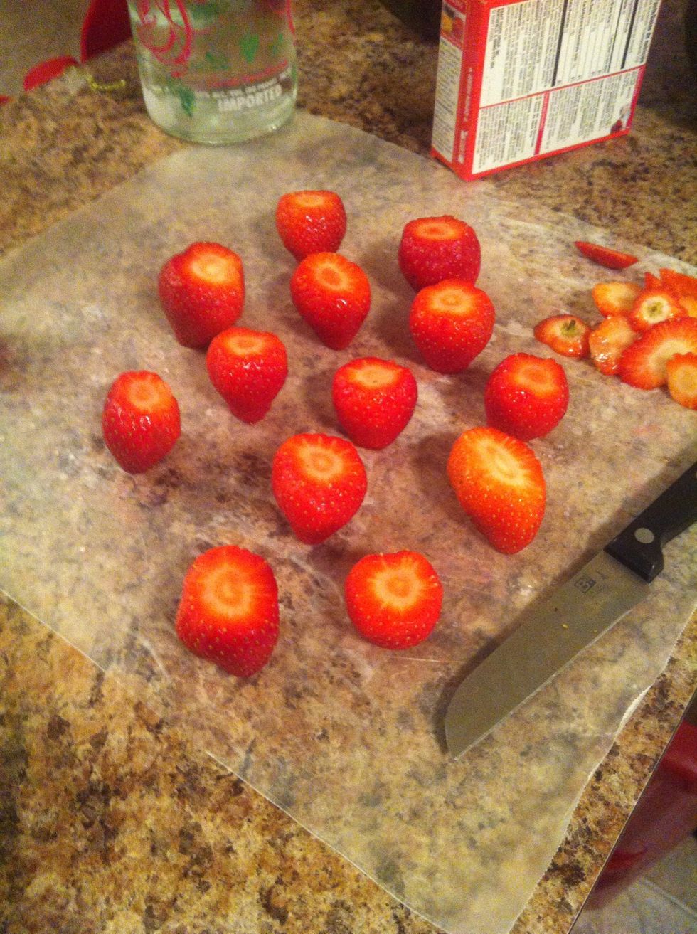 Cut the tops of the strawberries off, prepping for hollowing out the strawberry