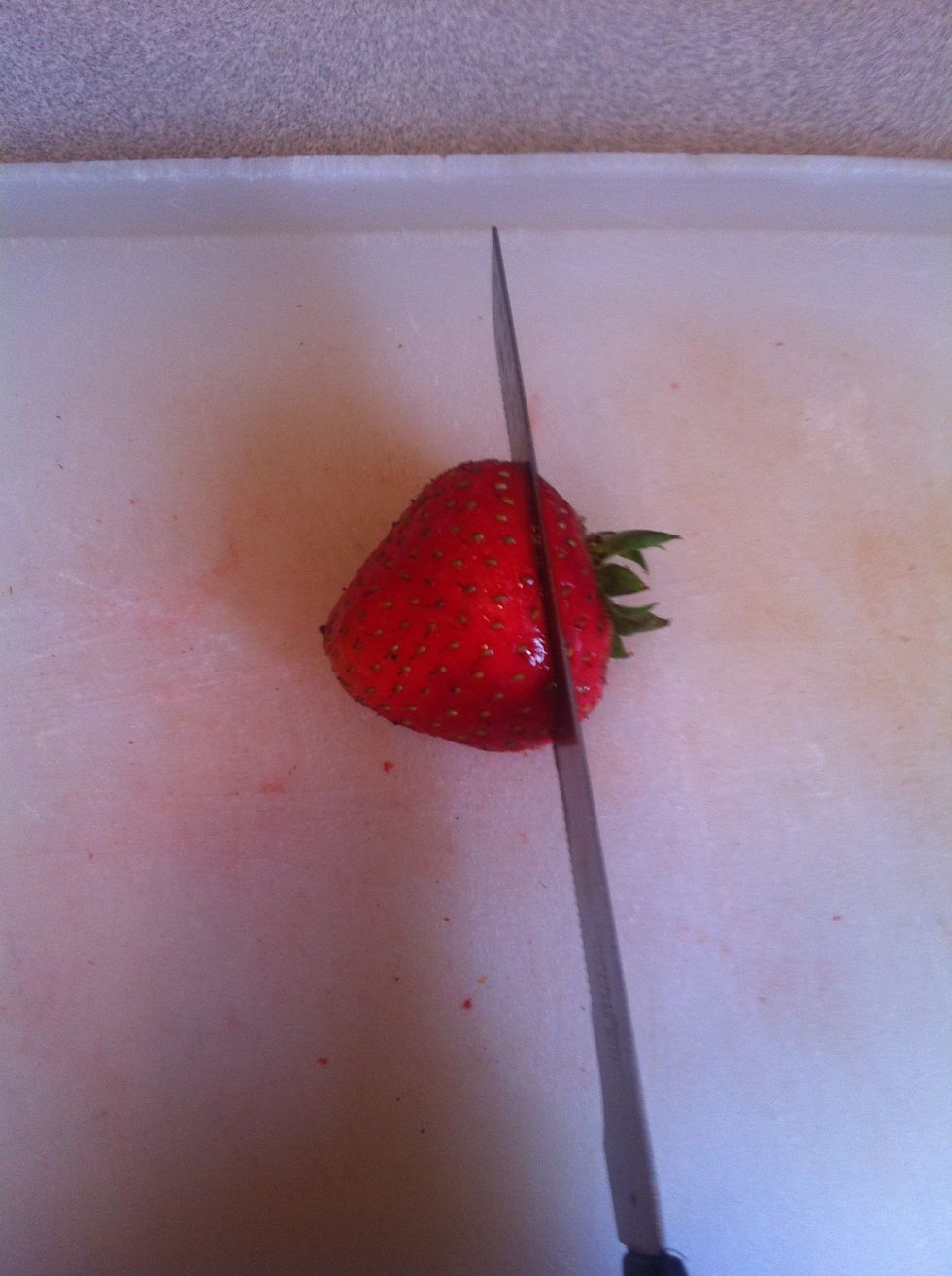 Cut the tops off strawberries.
