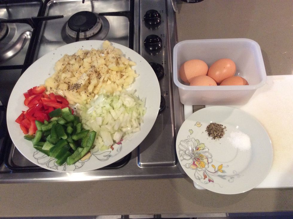 Cut the vegetables into diced pieces and gather them as shown into one plate, add salt and pepper to the vegetables, then put your eggs into a bowl or a similar container.