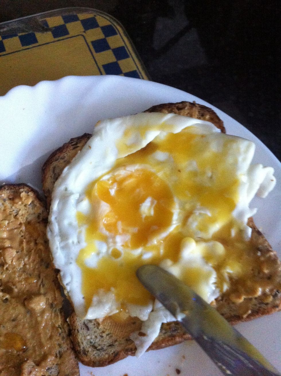 Cut the yolk and spread it evenly around the toast.