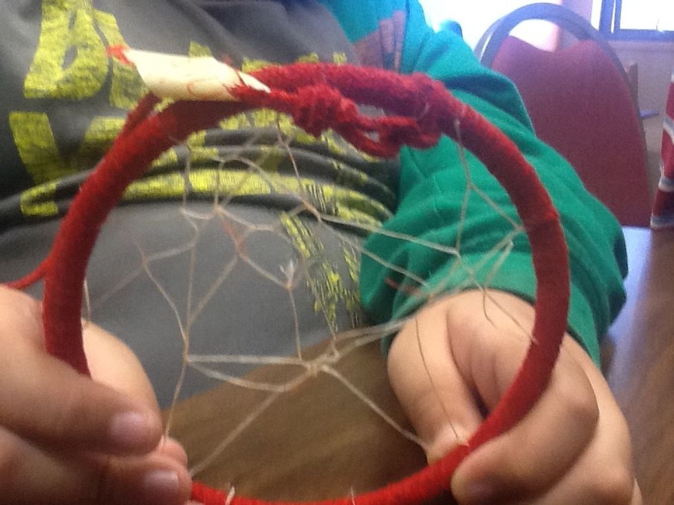 Cut three feet of sinew.  Tie a small knot with the sinew at the knot of the leather.