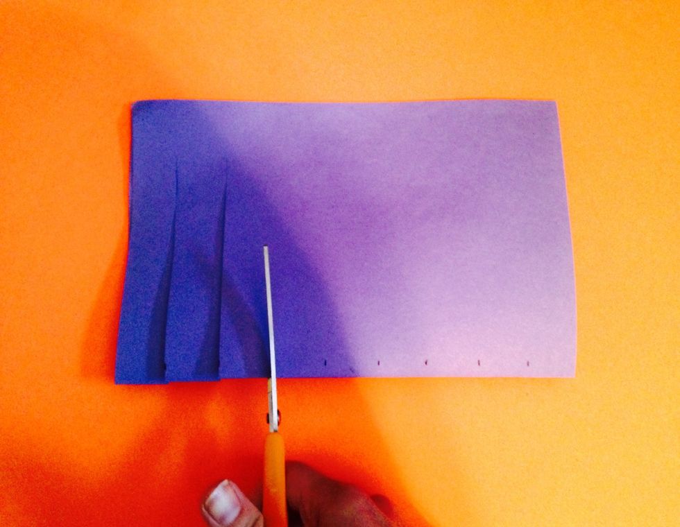 Cut through each of your inch marks on the folded side of the paper. Stop when you get about an inch from the end of your paper.