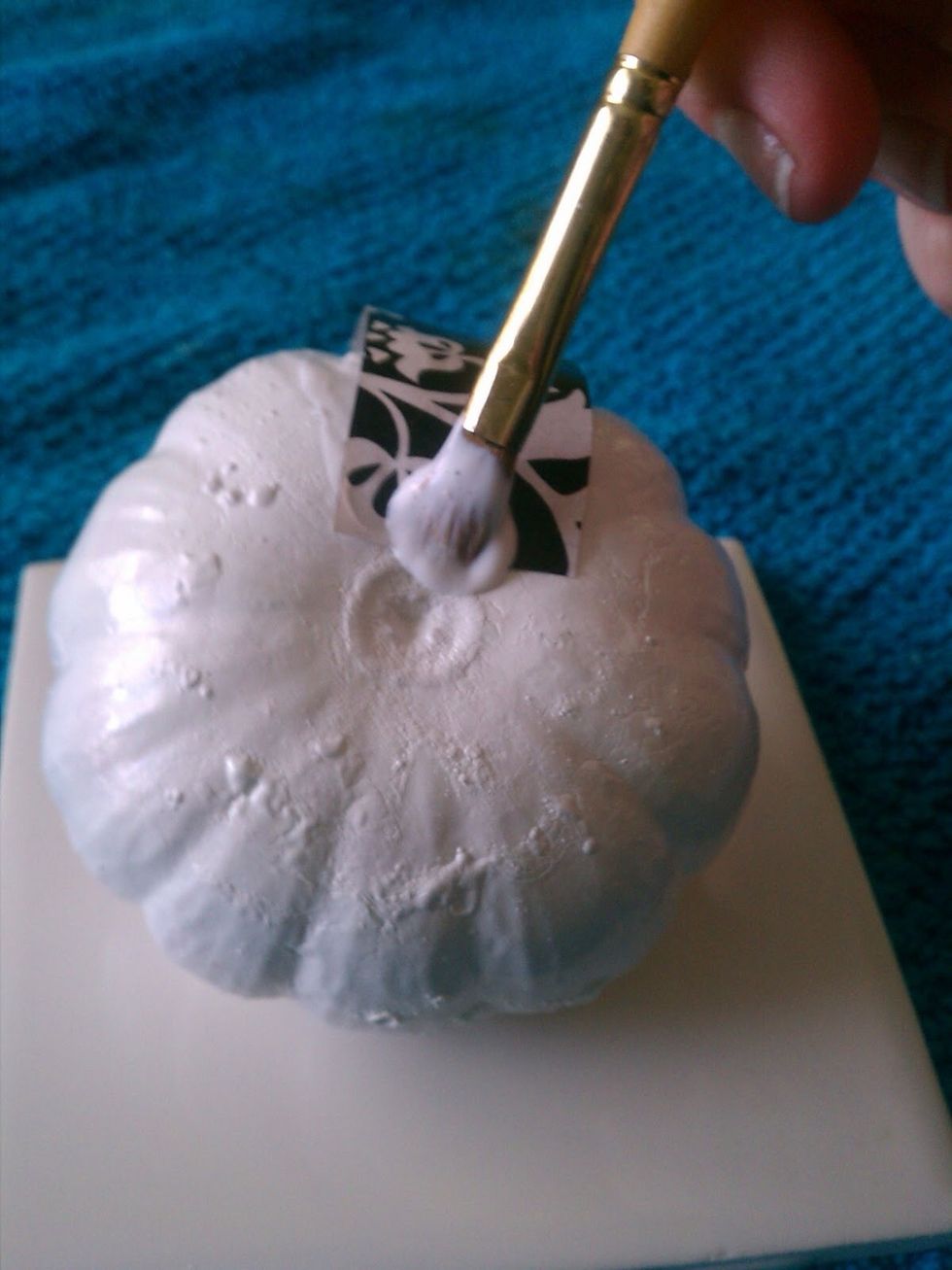 Cut tissue paper into small strips. Starting at the bottom, apply a layer of Mod Podge to the pumpkin, then lay the tissue. Apply another layer on top of the tissue.