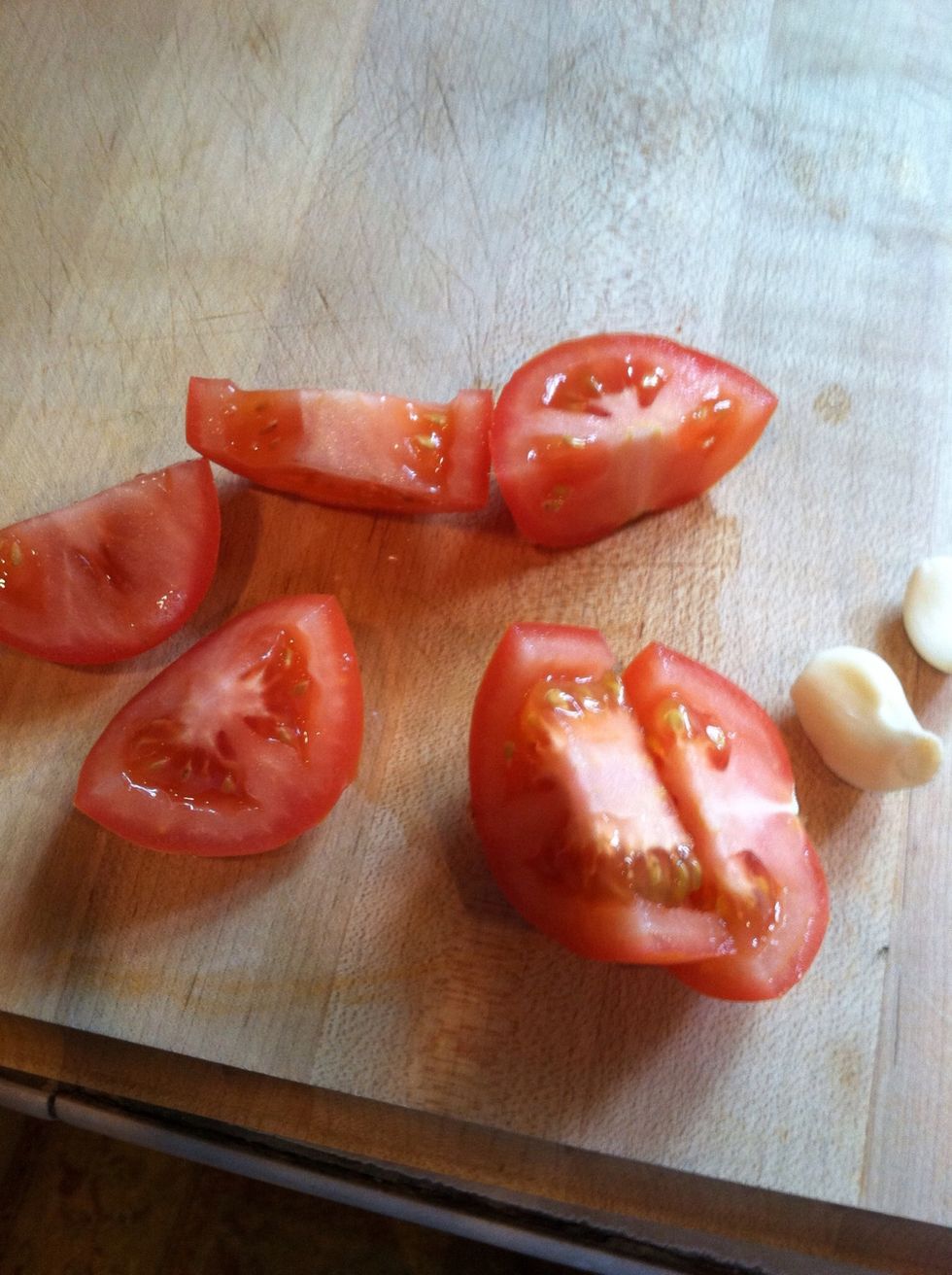 Cut tomato, and peel garlic cloves