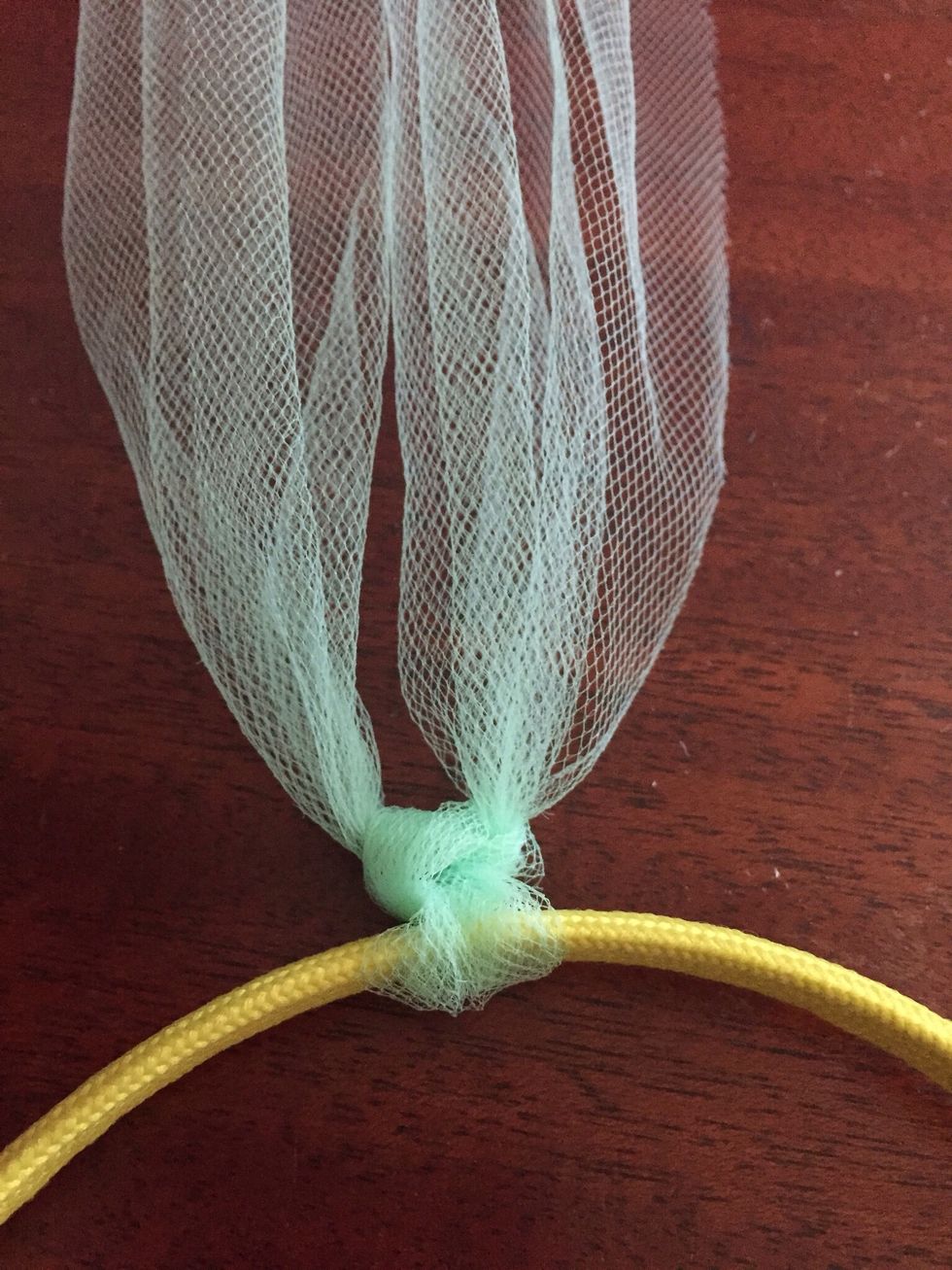 Cut tulle into 20  inch long strips.  You can use between 16-22 strips per headband.  Take one strip and 'even it' around the headband, and double knot it.