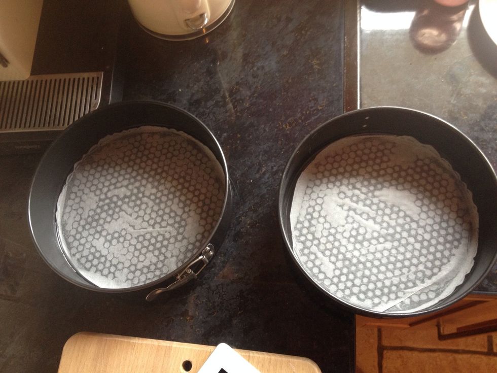 Cut two circles of grease proof paper to fit the bottom of both tins.