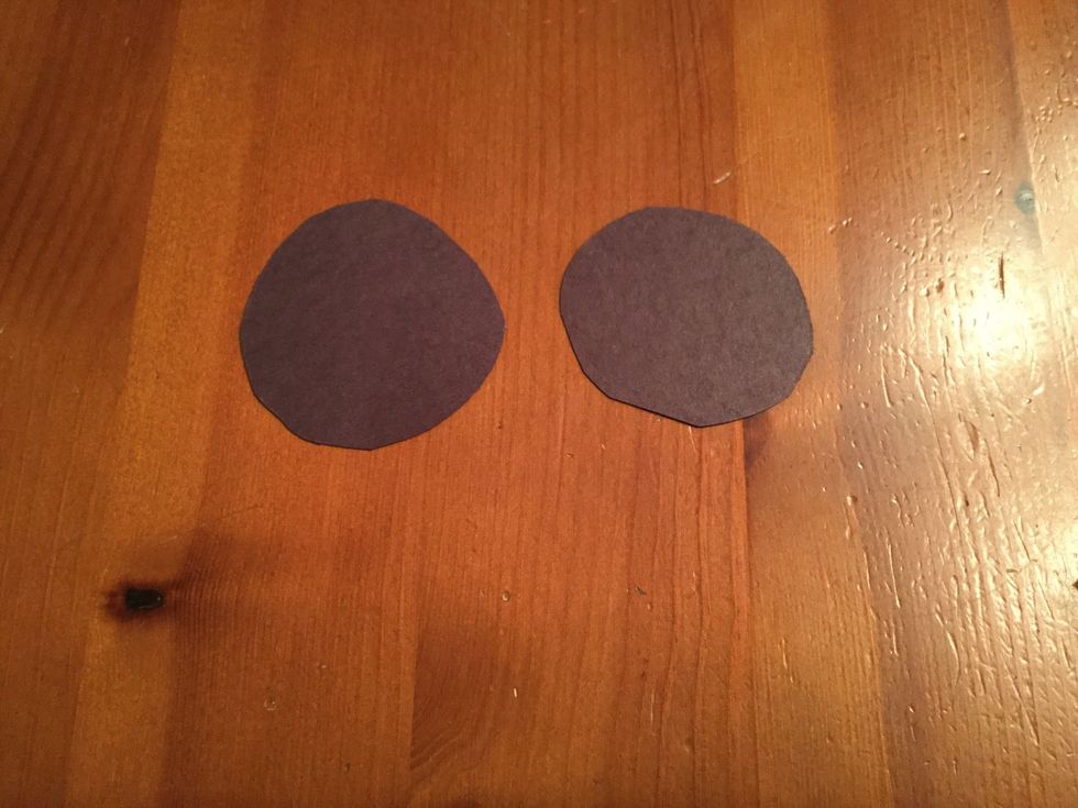 Cut two eyes out of the black paper.