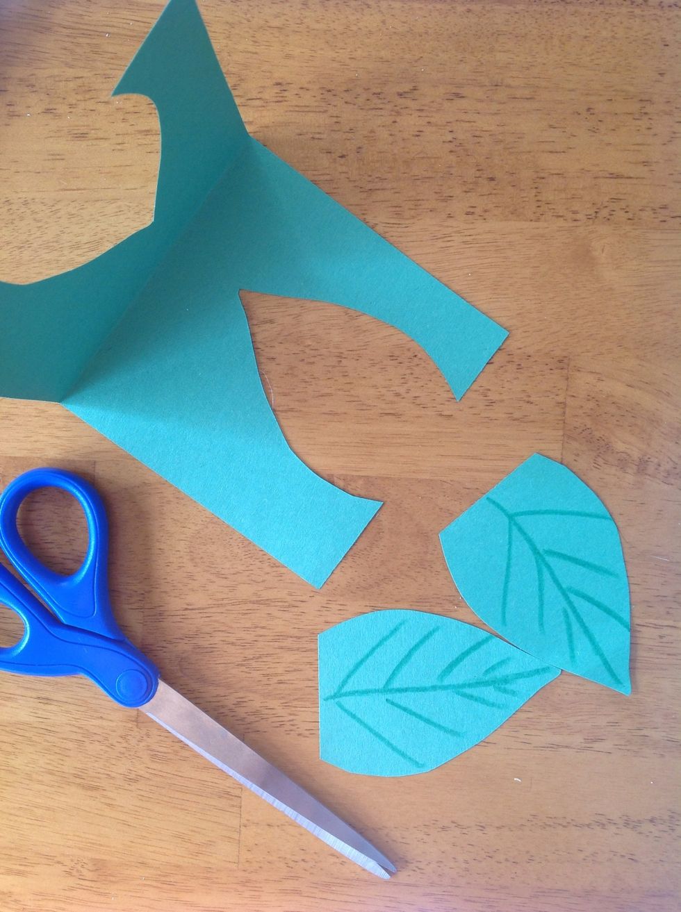 Cut two leaves out of green construction paper. Use crayons to draw lines on the leaves to make them look real.