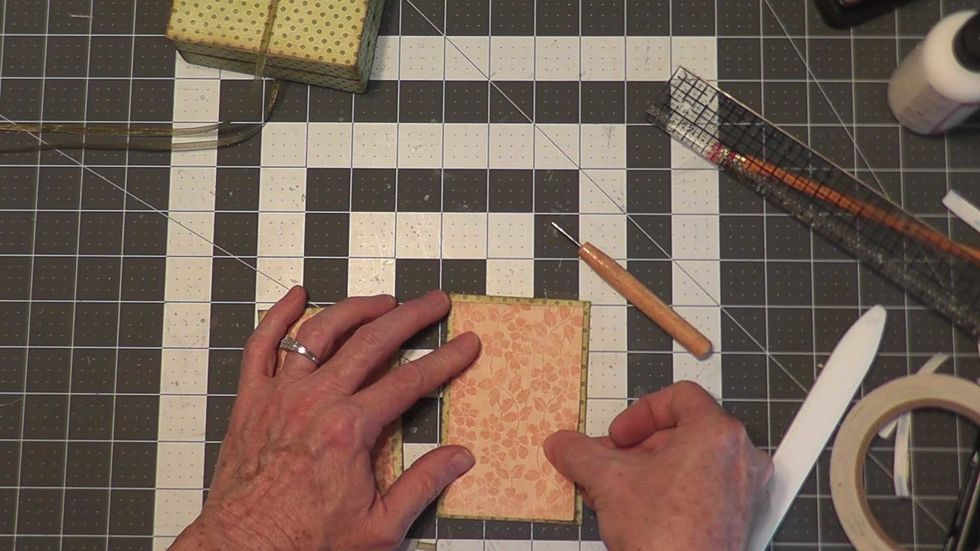 Cut two pieces of paper 2 3/4" x 4 1/2" and glue to the backside or inside area of each chipboard cover piece that you wrapped earlier.