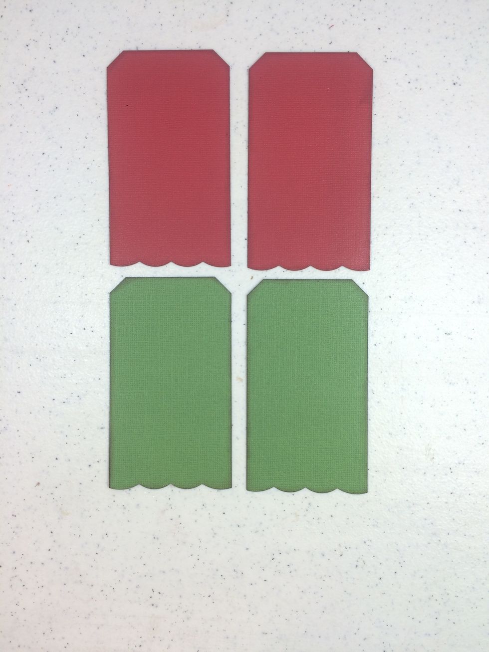 Cut two tag bases from green cardstock at 2 1/4" x 4". Do the same with red cardstock. Snip the top corners and cut across the bottoms with decorative scissors. Ink all edges with brown ink.