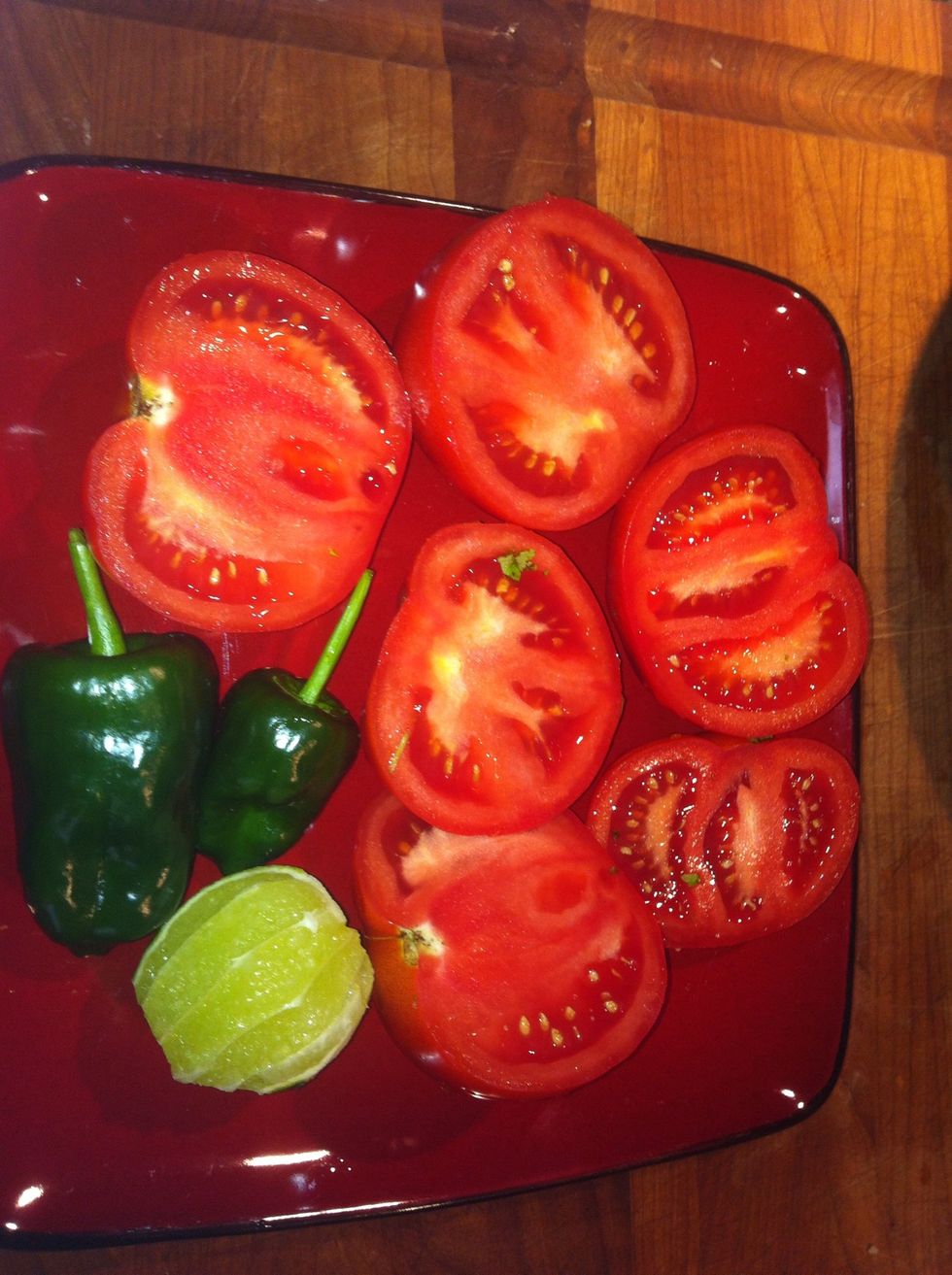 Cut up 3 tomatoes, peal a lime, cut up pepper. Add one or two peppers depending on how hot and spicy you want to make it.