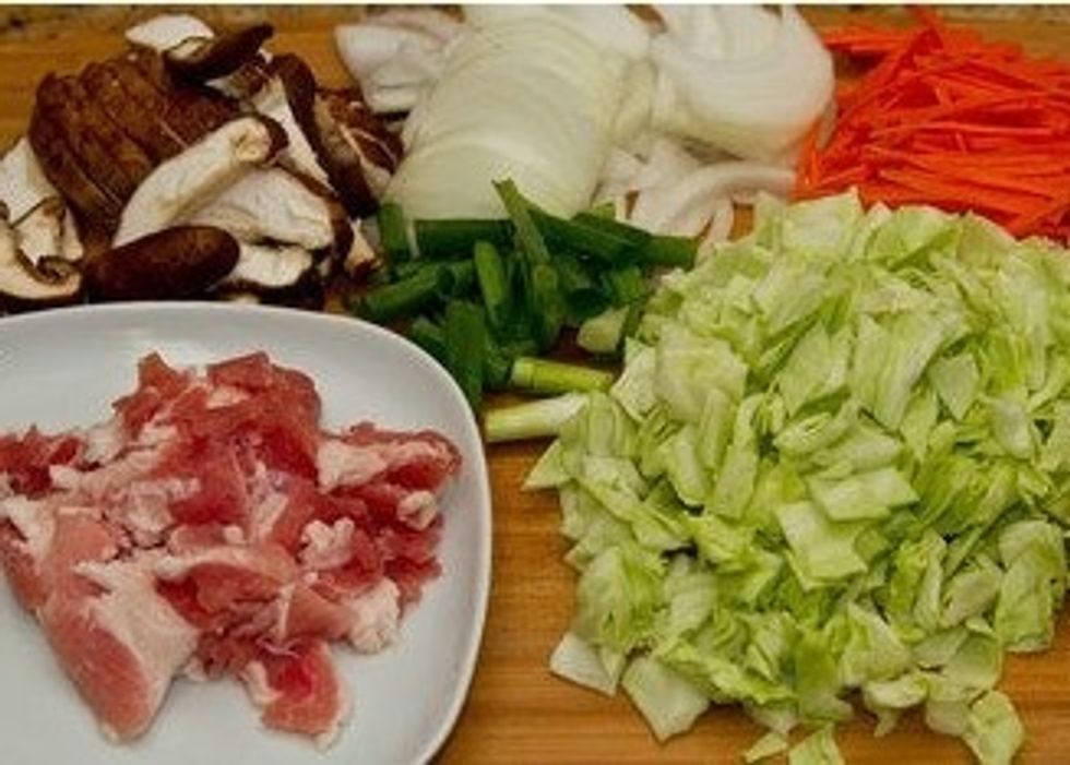 Cut vegetables and meat. Slice the shiitake mushrooms and the onion. Cut the carrot into julienned strips. Chop the green onion and the cabbage into smaller pieces. Cut the meat into 1 inch pieces.