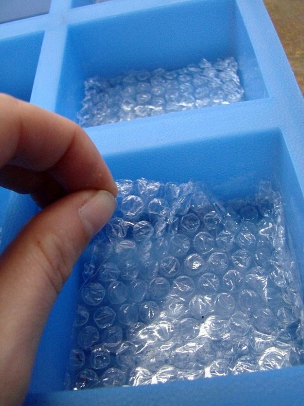 Cut your bubble wrap into squares that fit in the cavity and line your mold.