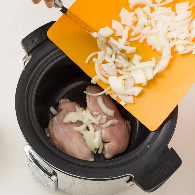 https://guides.brit.co/media-library/cut-your-onions-place-the-chicken-breasts-and-chopped-onions-into-the-slow-cooker.jpg?id=23797756&width=784&quality=85