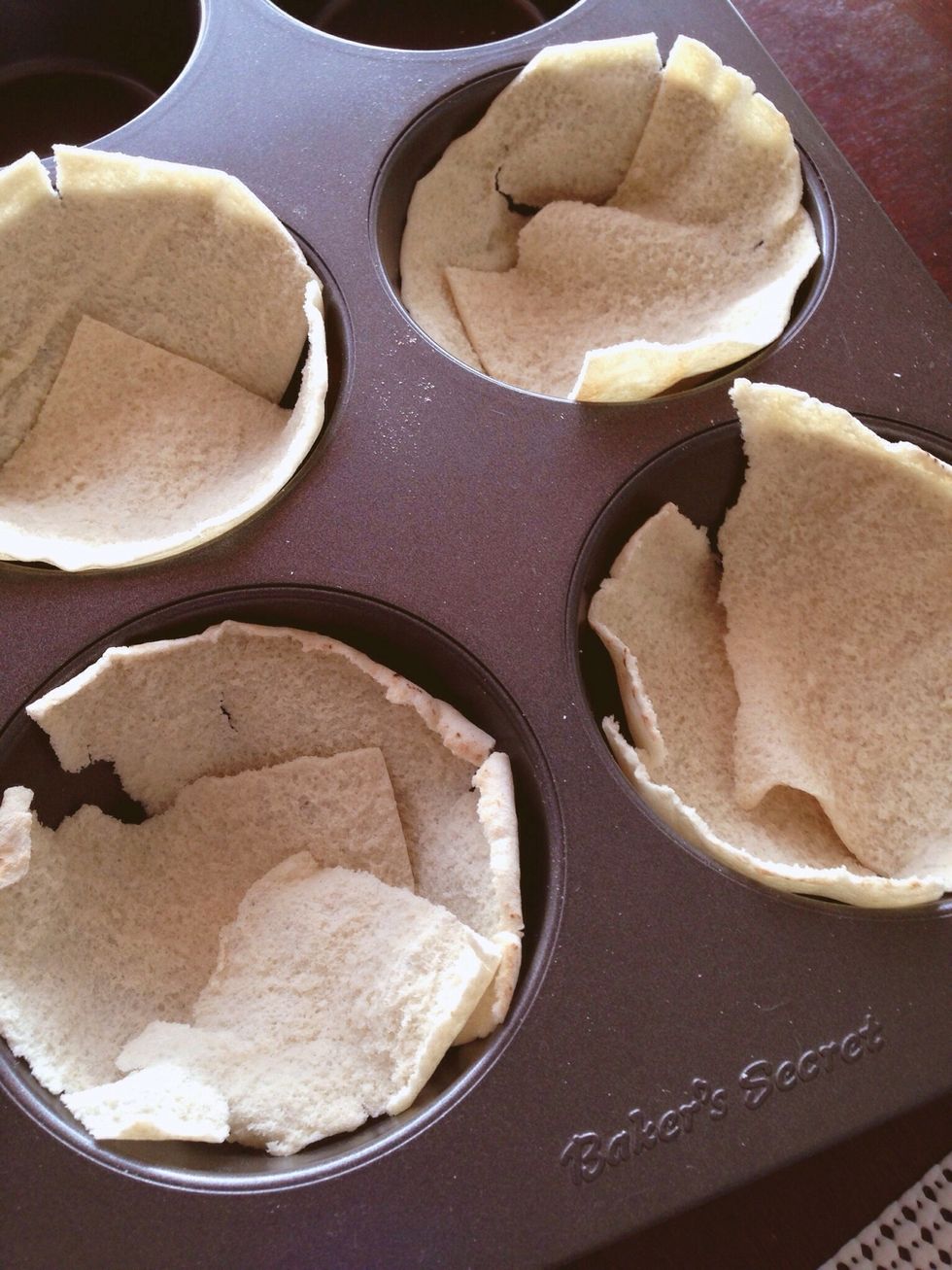 Cut your pitas in quarters and line the cups of your oversized muffin pan.