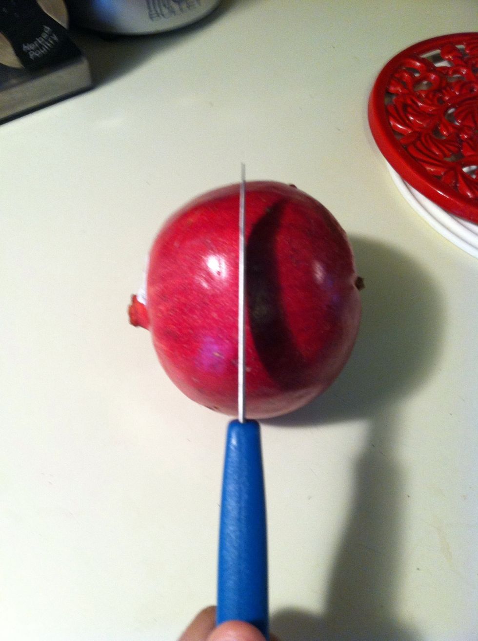 Cut your pomegranate in half this way. I usually cut it halfway and then pull it apart so that I avoid damaging the seeds.