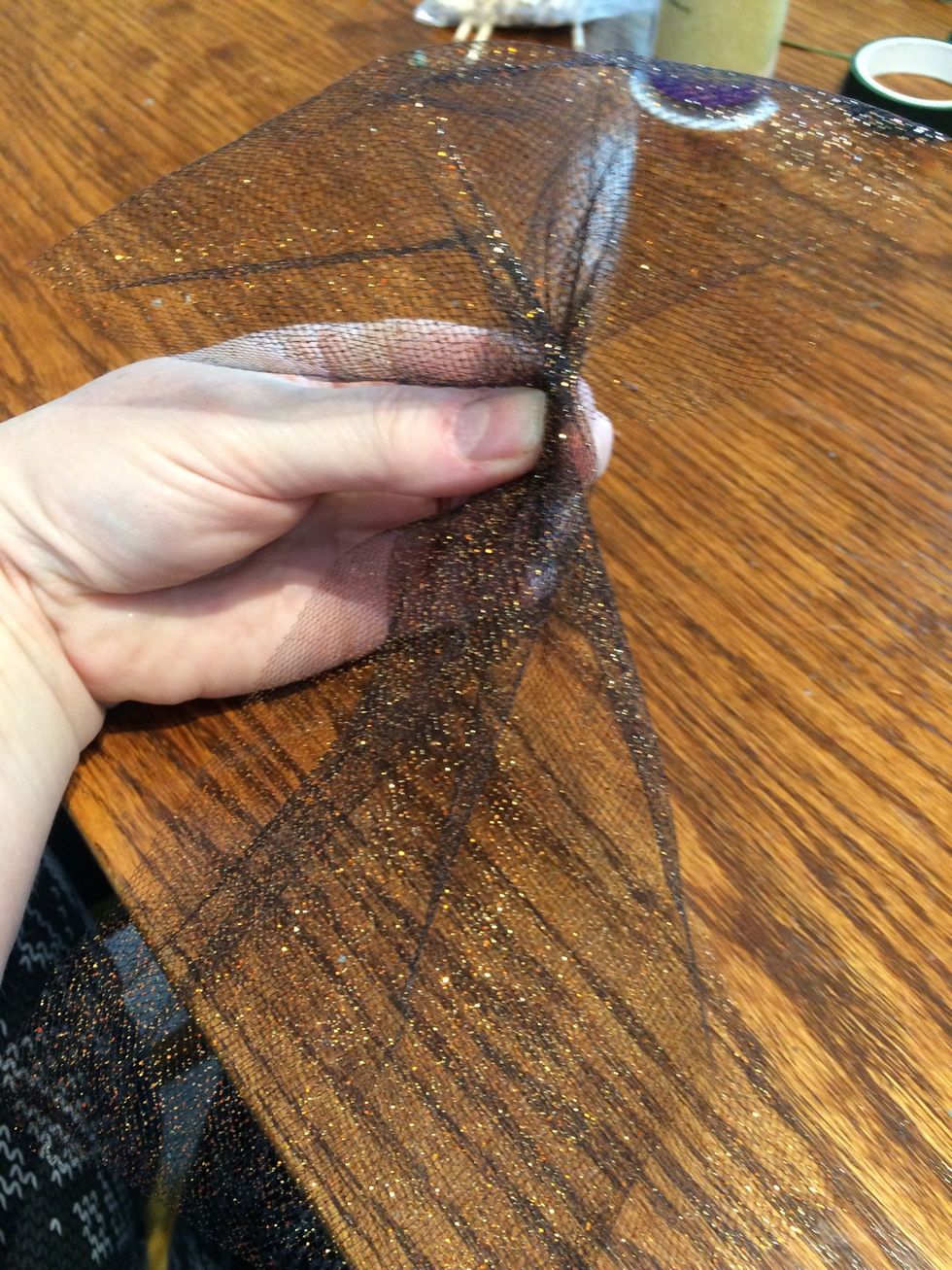Cut your tulle into 8 equal lengths of about a 10 to 12 inches each. Fold it in half, pinch to make a bunch at the loop.