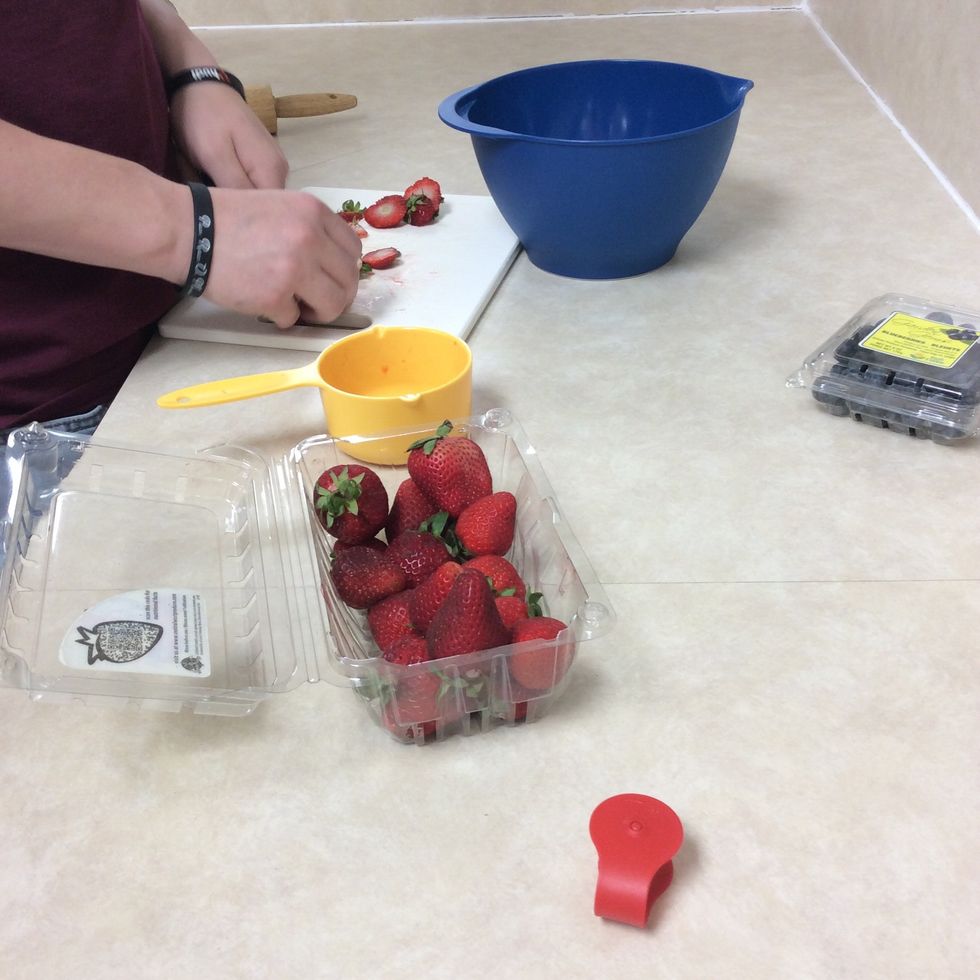 Cutting the strawberries and adding them to the bowl