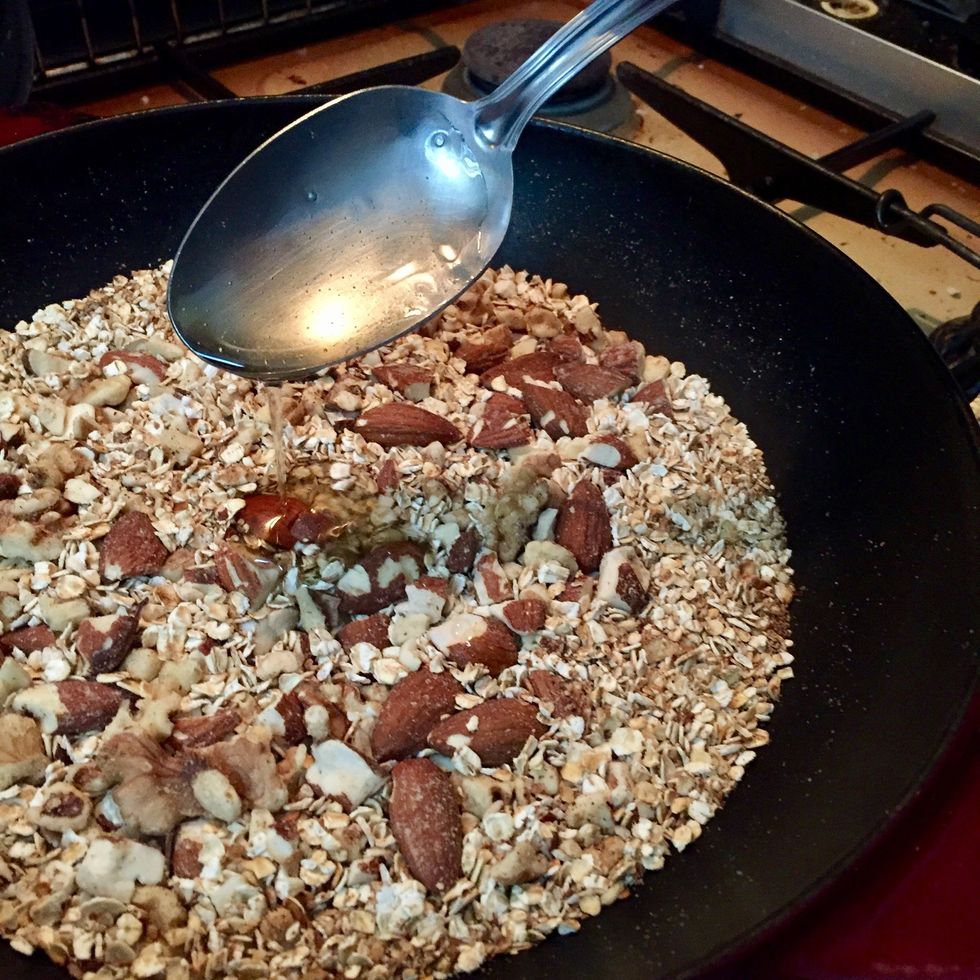 D\u00e8s qu'une douce odeur se d\u00e9gage des fruits secs (d\u00e9but de torr\u00e9faction) et que le m\u00e9langer commence \u00e0 se colorer, ajouter le miel. Bien m\u00e9langer.