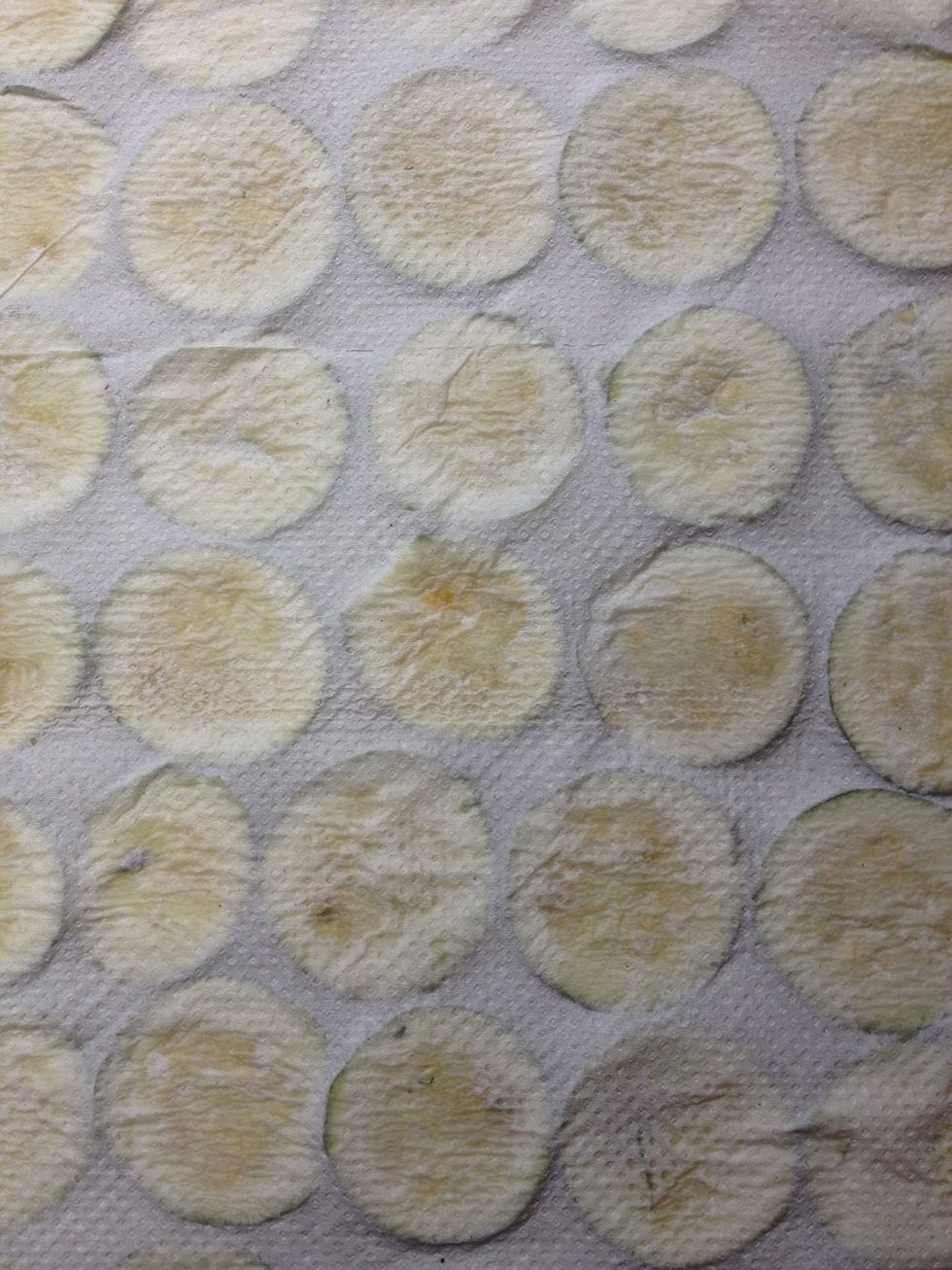 D\u00e9posez les tranches de courgette sur une feuille d'essuie-tout, recouvrez d'une deuxi\u00e8me feuille et appuyez pour absorber le maximum d'eau.