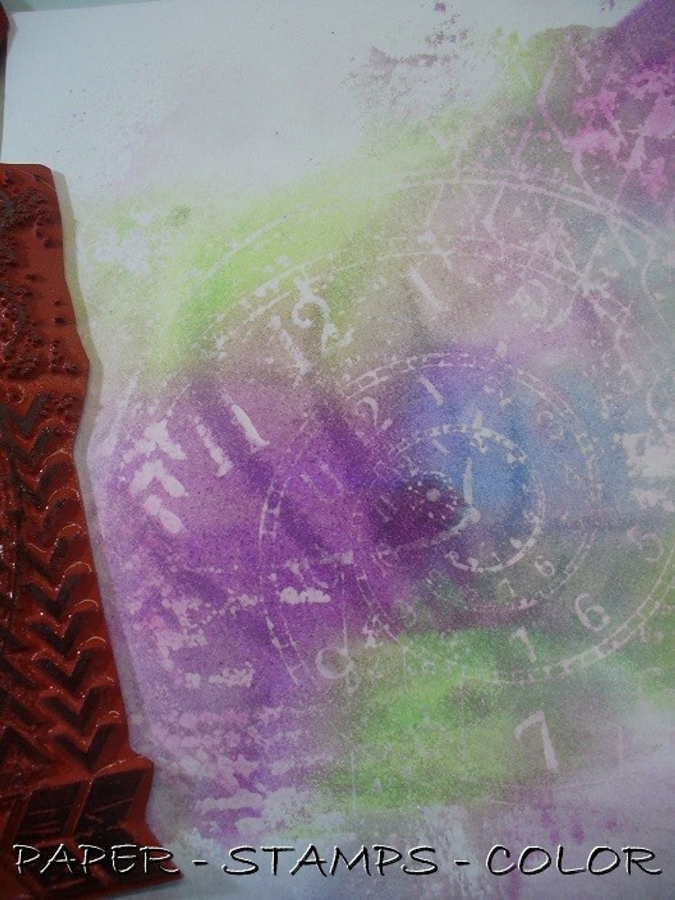 Dab some bleach onto the rubber stamp and stamp onto the background. Clean the rubber stamp immediately.