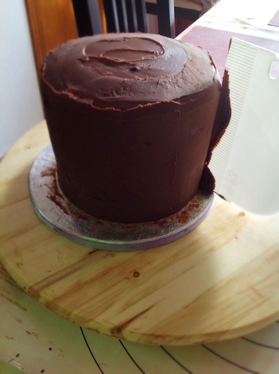 Damos una segunda capa bien generosa de ganache y repartimos bien por los laterales y parte superior y con ayuda del scraper bien recto en \u00e1ngulo, retiramos el exceso, tapamos todos agujeros.