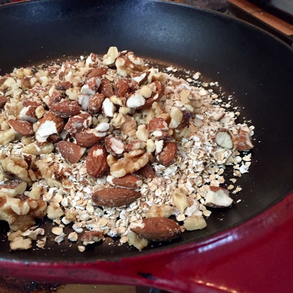 Dans une casserole, faire griller les flocons d'avoine, les noix et les amandes. Remuer avec une cuill\u00e8re en bois pour \u00e9viter que \u00e7a ne br\u00fble.