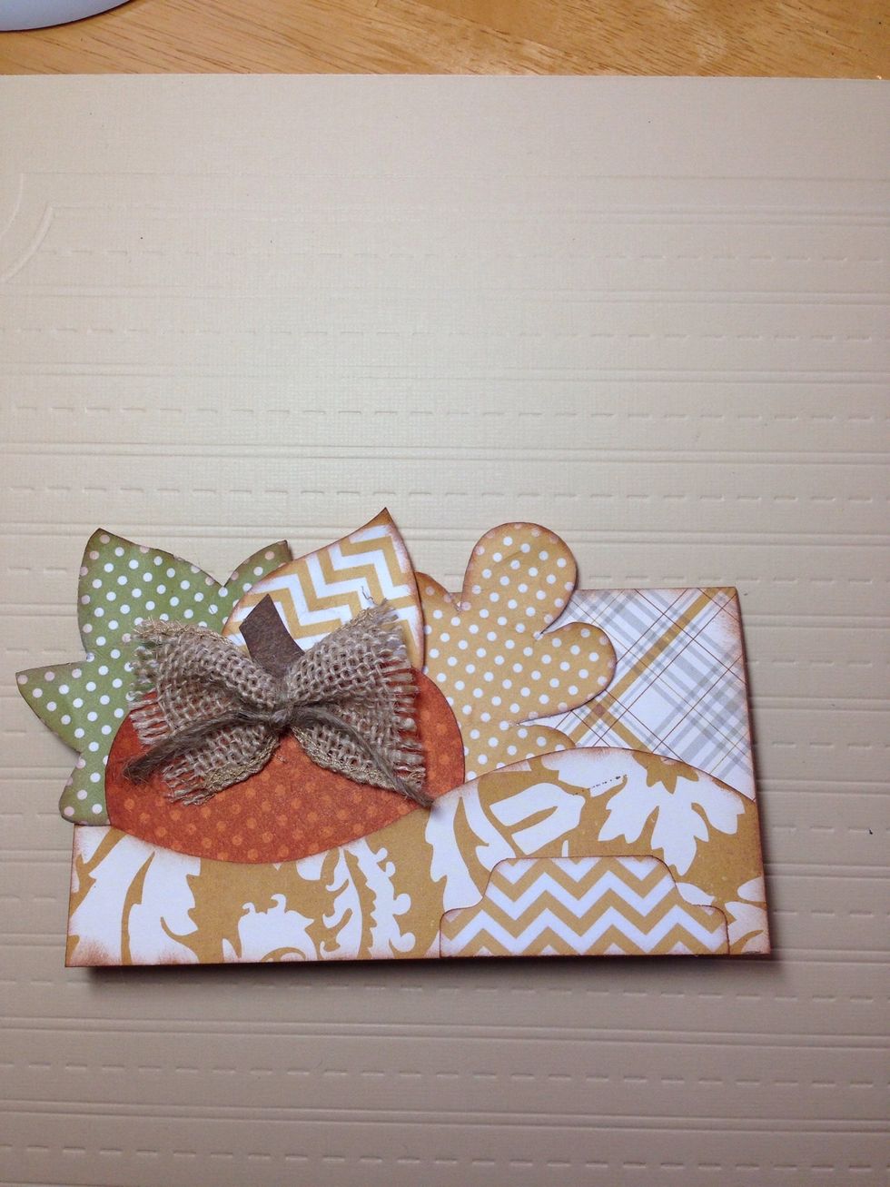 Decide how you want to arrange your leaves behind the pumpkin and then adhere them to the card. Add adhesive to any spot that still needs it.