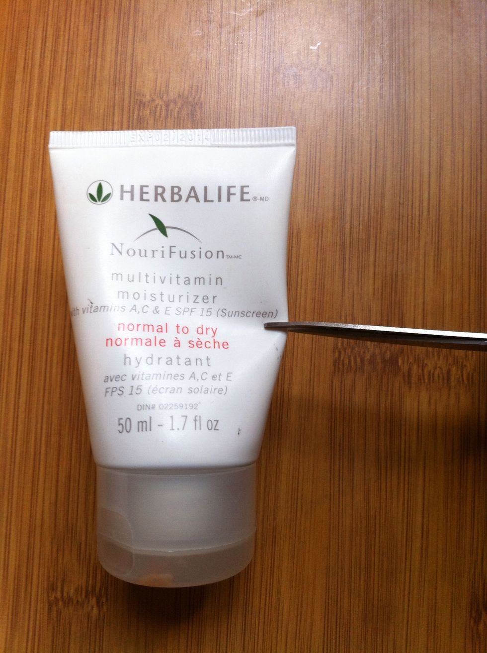 Decide where you want to cut your container (somewhere around the middle) and make a small cut with your scissors.