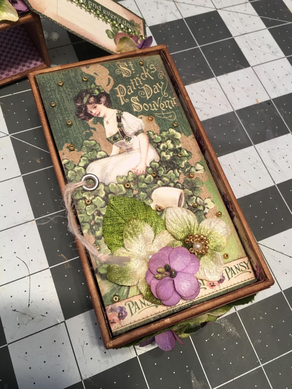 Decorate the first page of the fold out by gluing on leaves and flowers and gold seed beads.