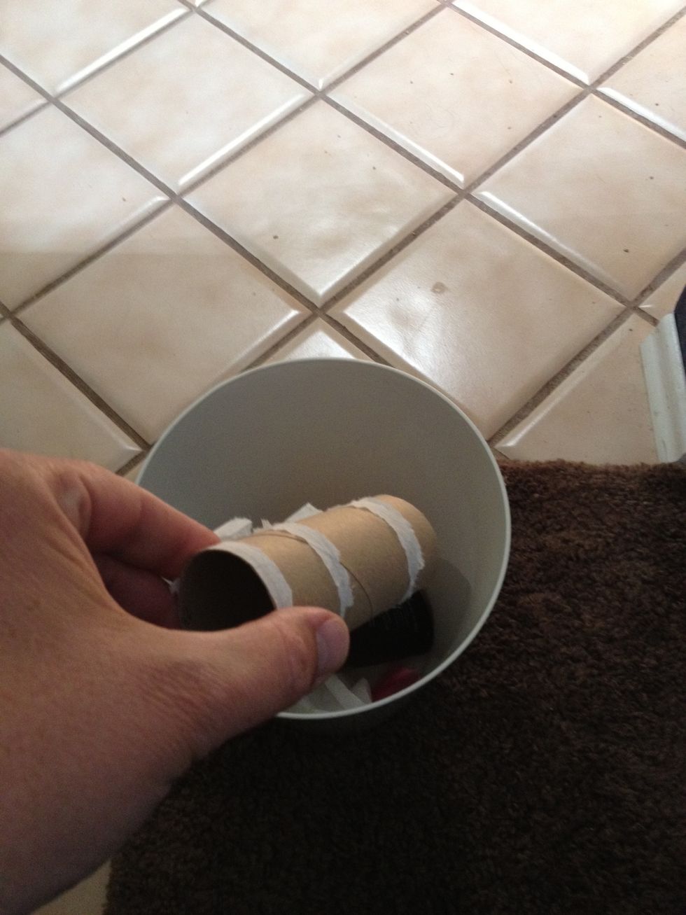 Deposit empty cardboard toilette paper roll in  waste bucket.