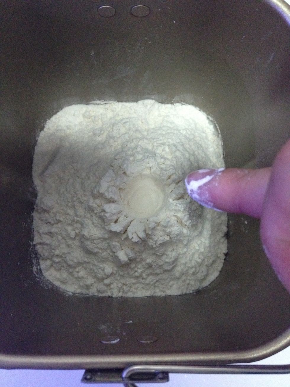 Depress and create a small crater on the flour with your finger.