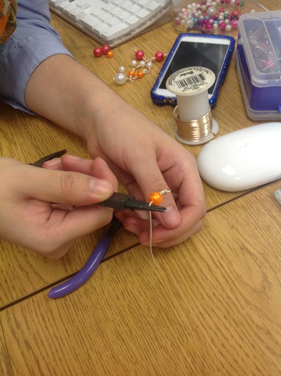 Despues agare sus alicates redondas y p\u00ednchelo con un espacio en el medio de sus alicates y la cuenta.