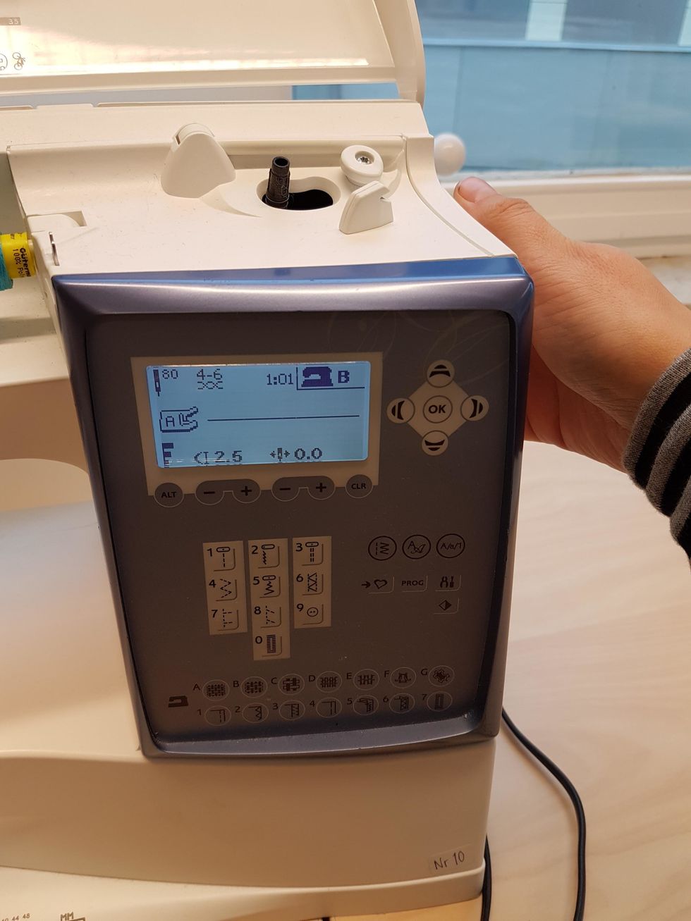 Det h\u00e4r har jag redan hj\u00e4lp till med! Tr\u00e4 maskinen med samma f\u00e4rg p\u00e5 tr\u00e5den som dragkedjan. Sy raks\u00f6m fyra g\u00e5nger dragkedjans kanter genom att vrida p\u00e5 handhjulet.