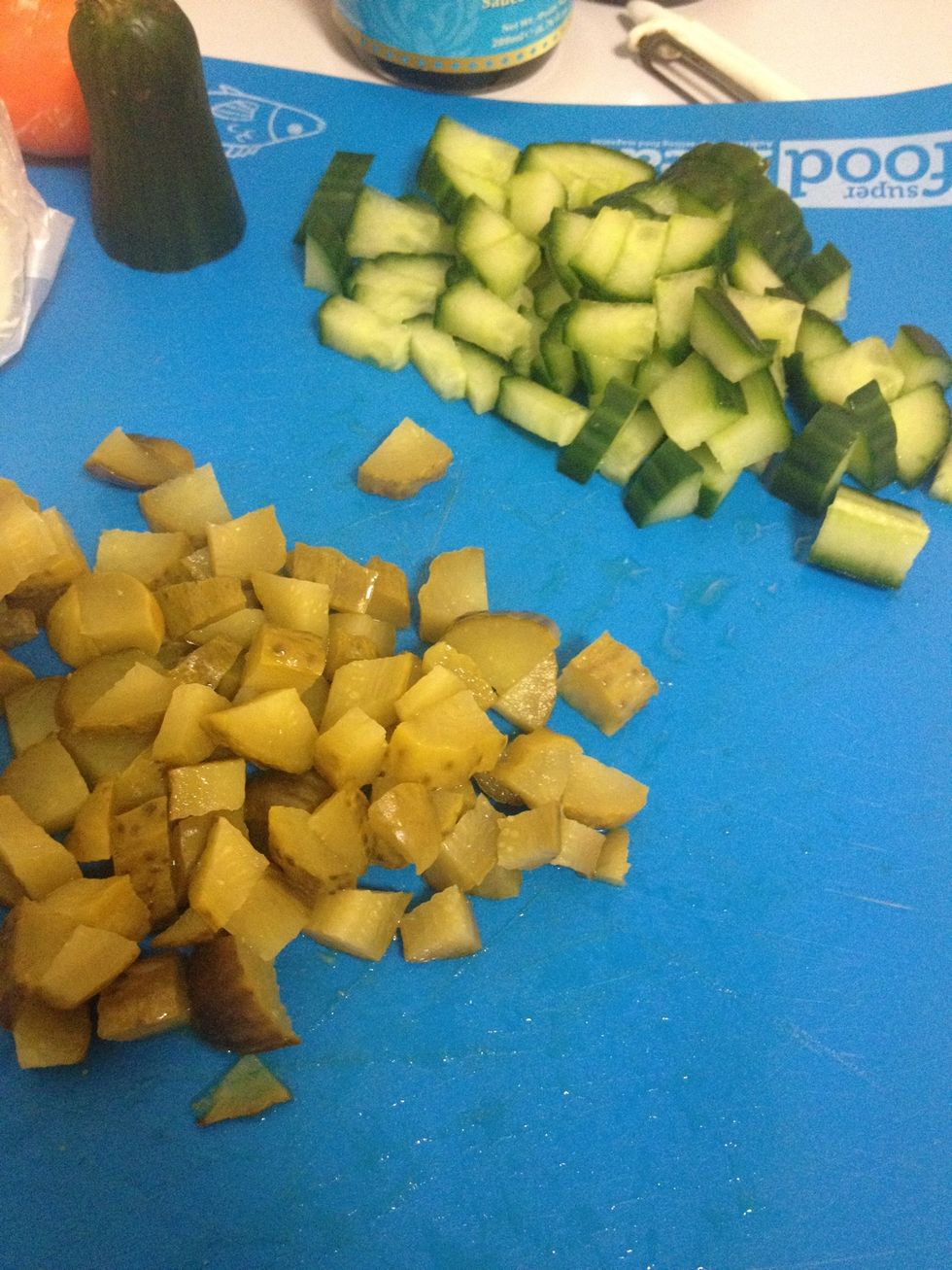 Dice cucumber and gherkin finely