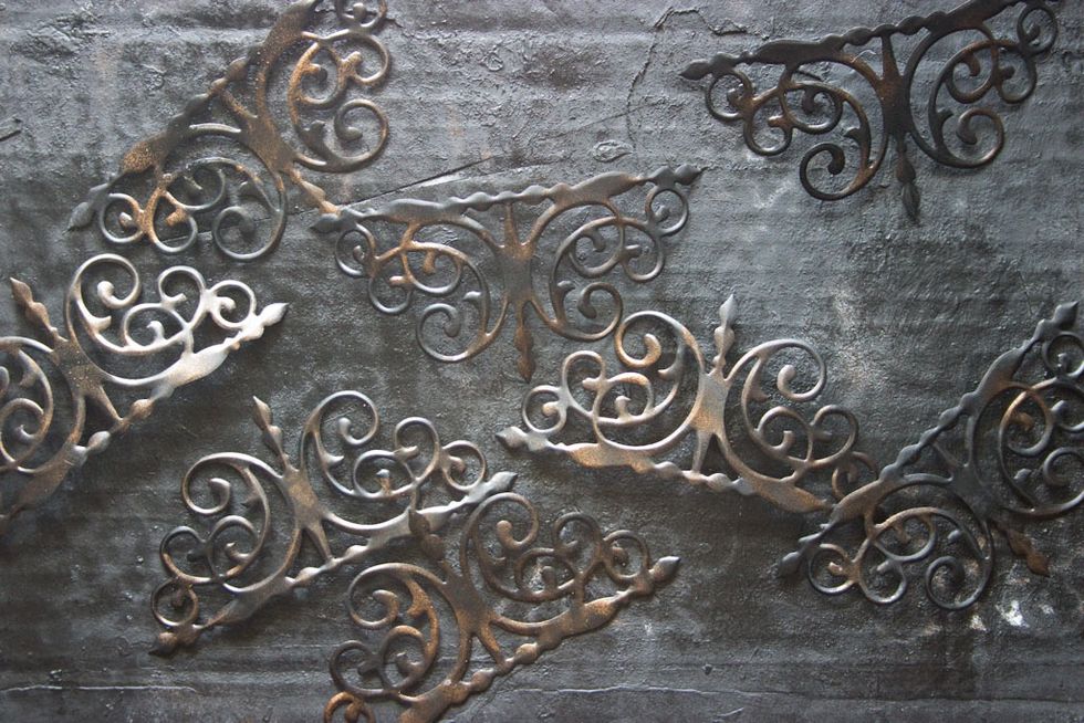 Die cut recycled Soda Cans, paint black, and highlight with "Steampunk Copper". (This die is "Curly Gate" by Sizzix)