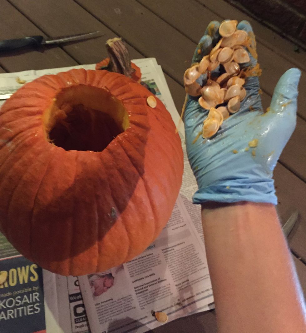 Dig down into the pumpkin and grab handfuls of guts. Pull them out and place them in your plastic bag. Continue doing this until all the guts are removed.