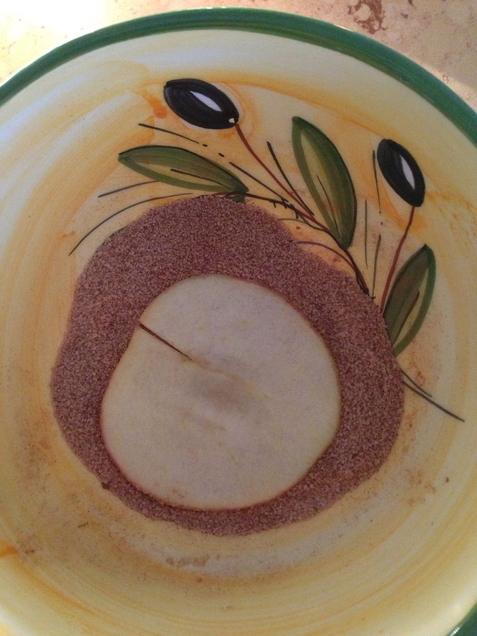 Dip a piece of apple into the sugar and cinnamon mix.