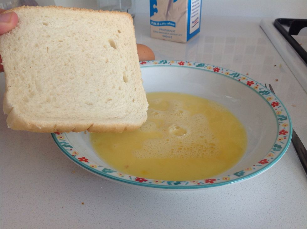 Dip both sides of a slice of bread in the egg mixture. It is important that the bread is not soaked in the mixture.