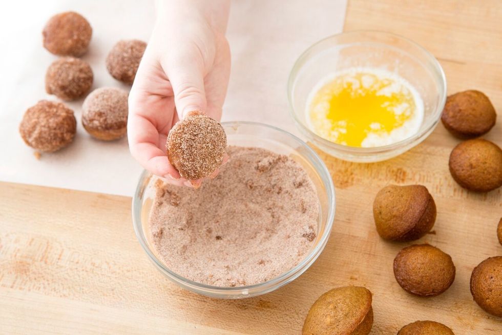 Dip donut hole in cinnamon sugar mixture. Roll donut hole around in mixture to ensure total coating.