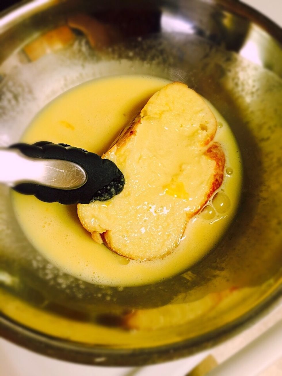 Dip each slice in the egg mixture both sides. The fresher the bread the quicker you need to be. If bread is hard you can leave the slice to soak for about 15 seconds. If it's fresh dip it fast and fry