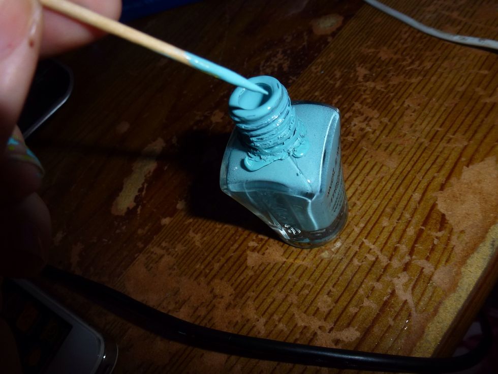 Dip it in the nail polish, but don't make it drip, because it will only make a mess and we don't want that. Just dip it enough for making the dots for the flowers .