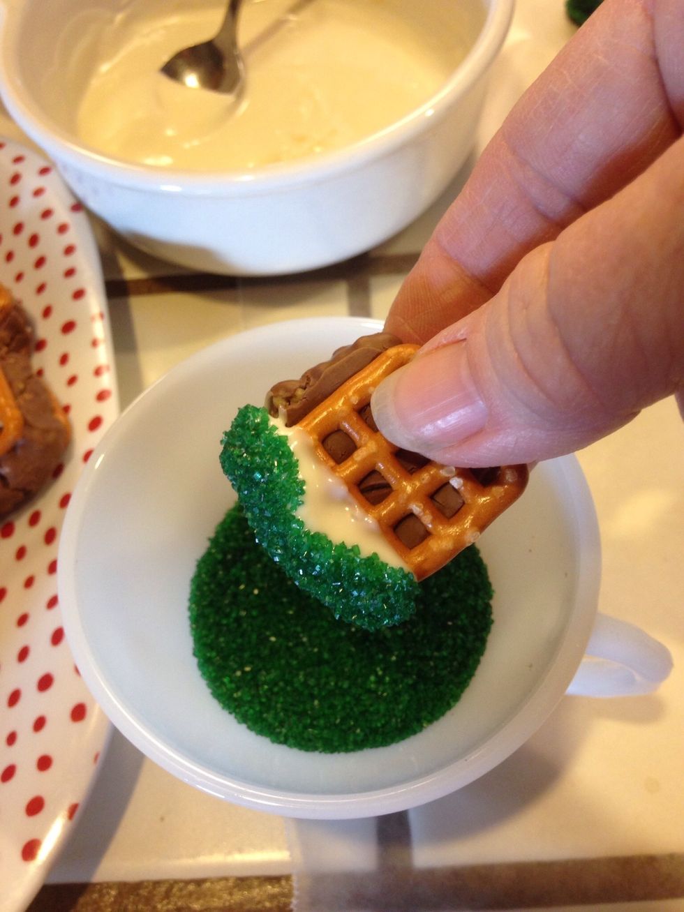 Dip pretzel into sprinkles.