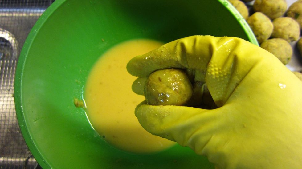 Dip the fish balls in the egg mixture. Best is to dip and wiggle it around the bowl by hand. All you need is a light even coating of egg.