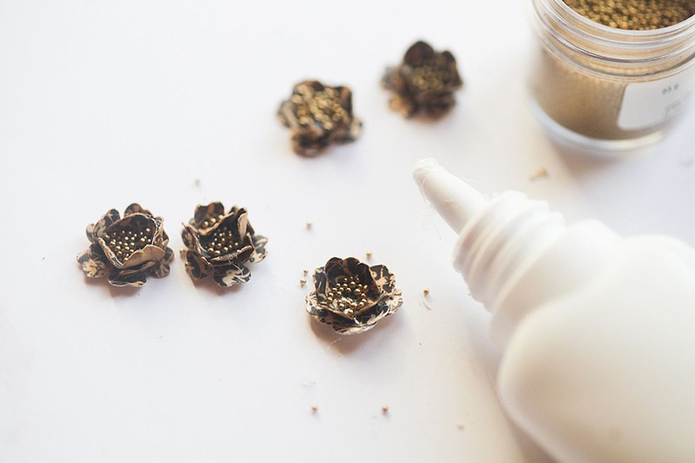 Dip the pieces into coffee, crumple, dry and make 3 layers to get a good flower. Fill the middle with glue and sprinkle with golden beads.