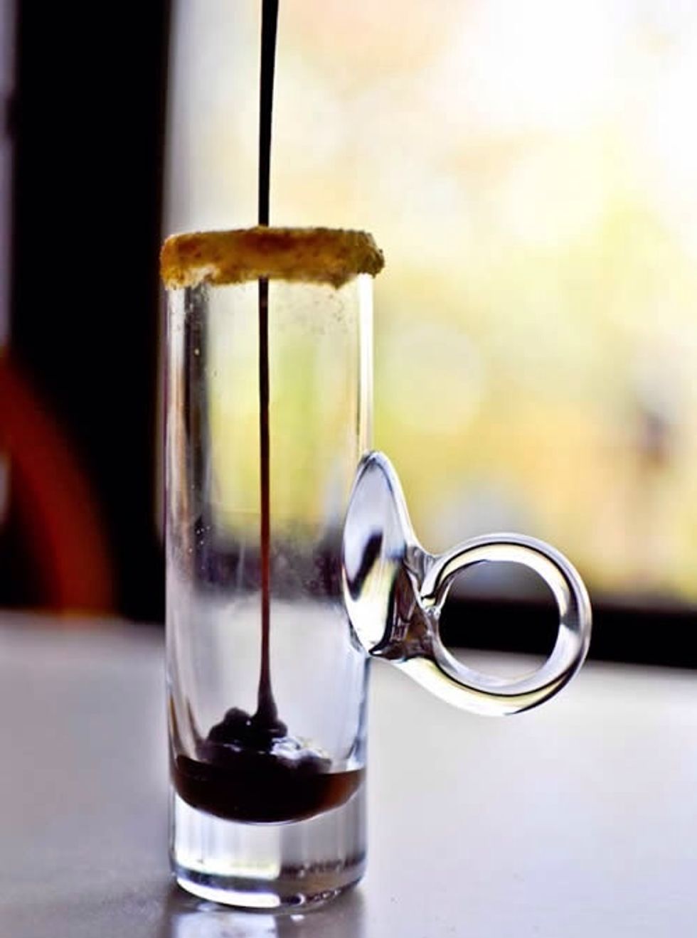 Dip the rim of your glass in a bit of frosting, then dip into graham cracker crumbs. Pour about 1/2 teaspoon chocolate fudge into the bottom of the glass.
