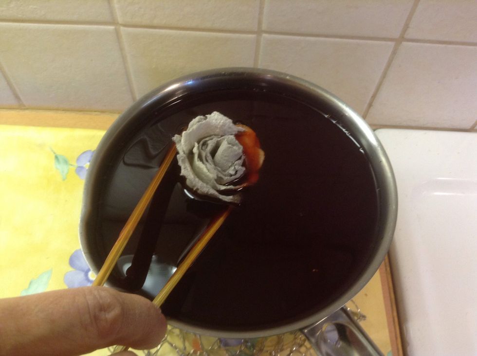 Dip the rose into the melted candle wax.