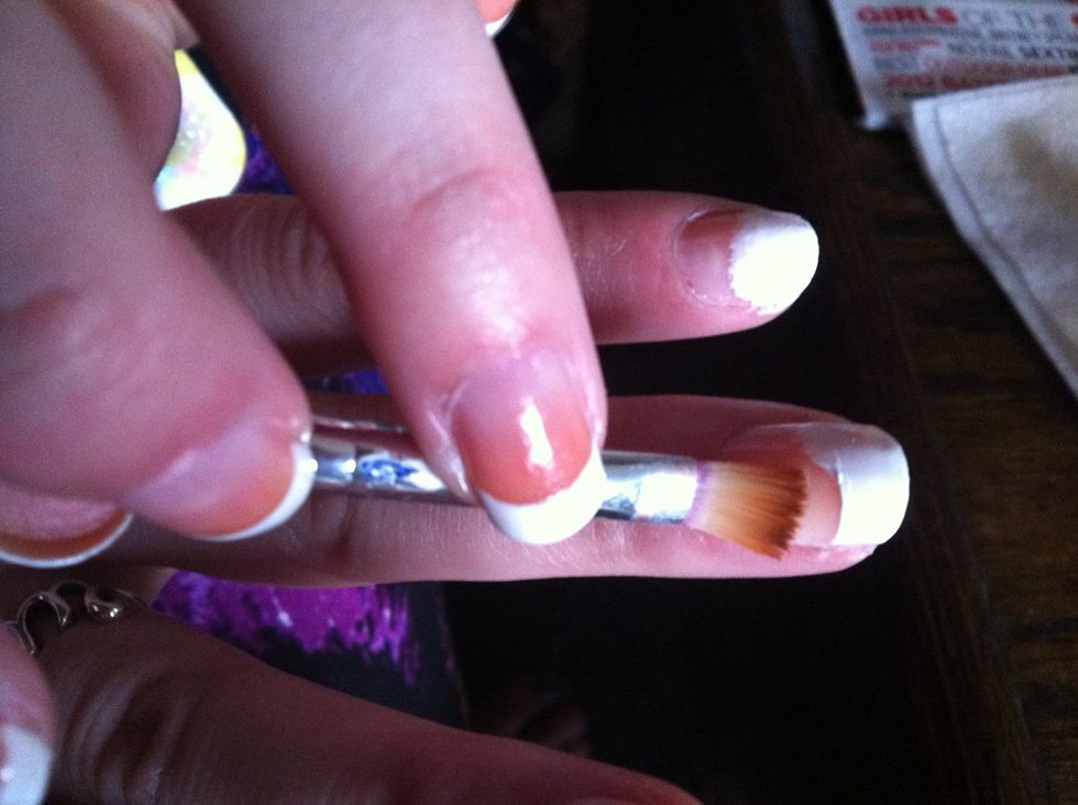 Dip the small paintbrush in acetone and use it to erase the white polish until the tips are the width you want and have a smooth edge. Dab off excess polish and acetone on a paper towel.
