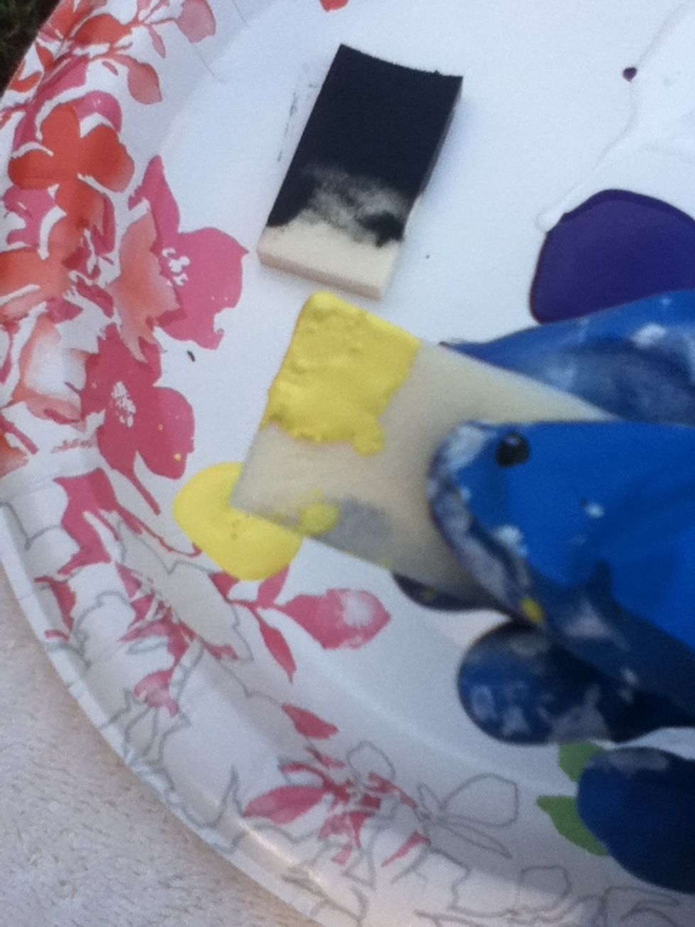 Dip the sponge in yellow paint.