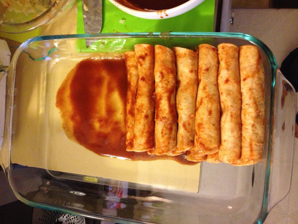 Dip tortilla in the sauce. Place it in your baking dish and start adding a bit of your chicken or potato filling. Roll it up and set on the edge of the dish. Keep dipping and rolling until done.